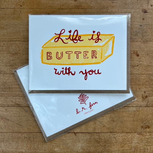 Greeting card with 'Life is butter with you' text on a wooden surface